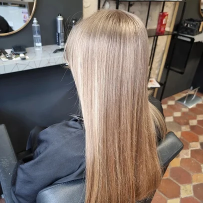 Cheveux longs blonds raides tombant sur le dos d'une personne assise.